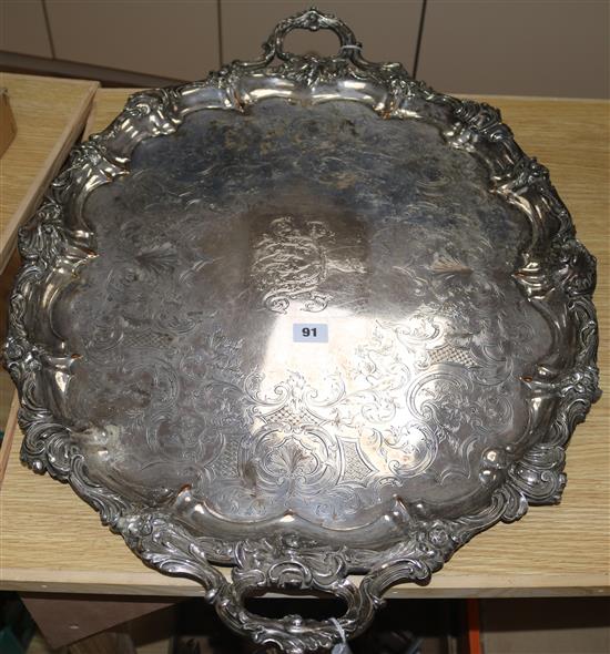 A large plated twin-handled engraved oval tray, the edges cast with foliate scrolling and flowers (wear to plate)